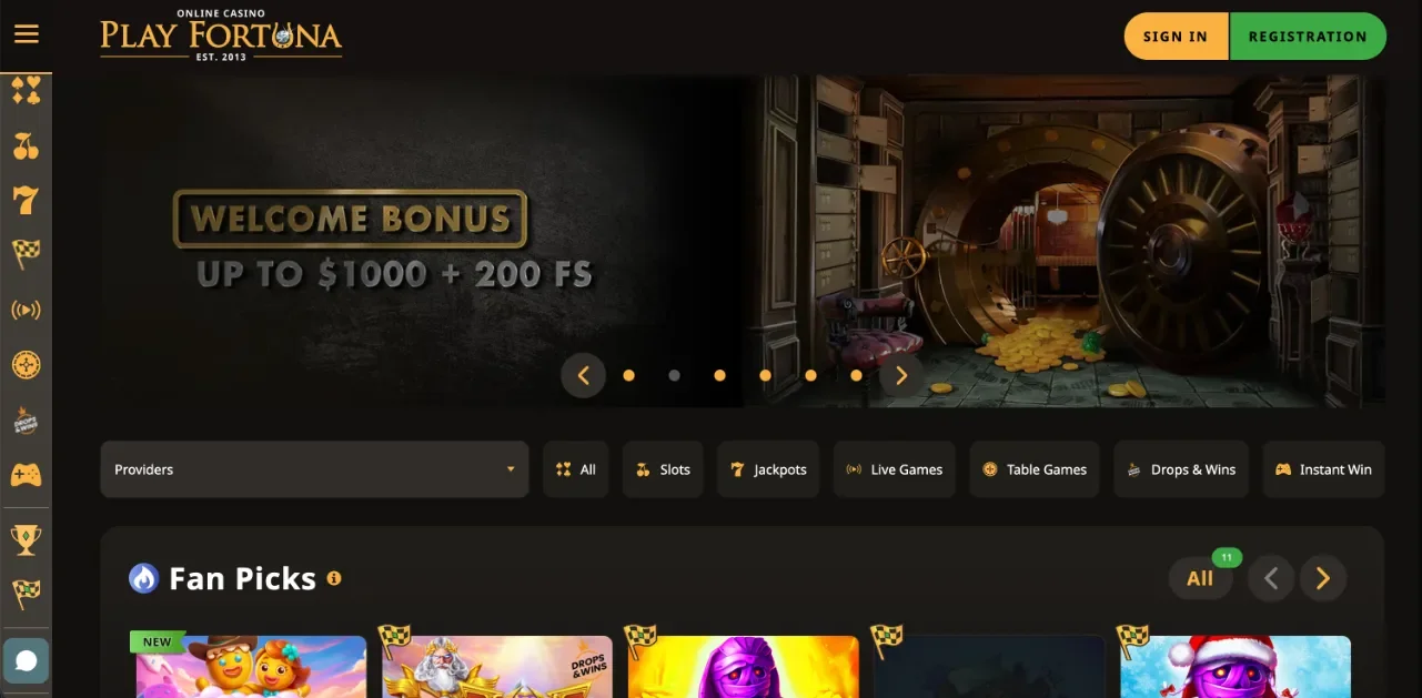 Play Fortuna kezdőképernyő — karuszelben üdvözlő bónusz akár 1000 $ + 200 ingyenes pörgetés széfgrafikával és arany betűkkel, PLAY FORTUNA EST 2013 logó, bal oldali vertikális ikonmenü, „Fan Picks” sor Drops & Wins jelvényekkel, All / Slots / Jackpots / Live Games / Table Games / Drops & Wins / Instant Win szűrősáv — prémium sötét arany UI (szerkesztőségi képernyőkép a teljes Play Fortuna értékeléshez).